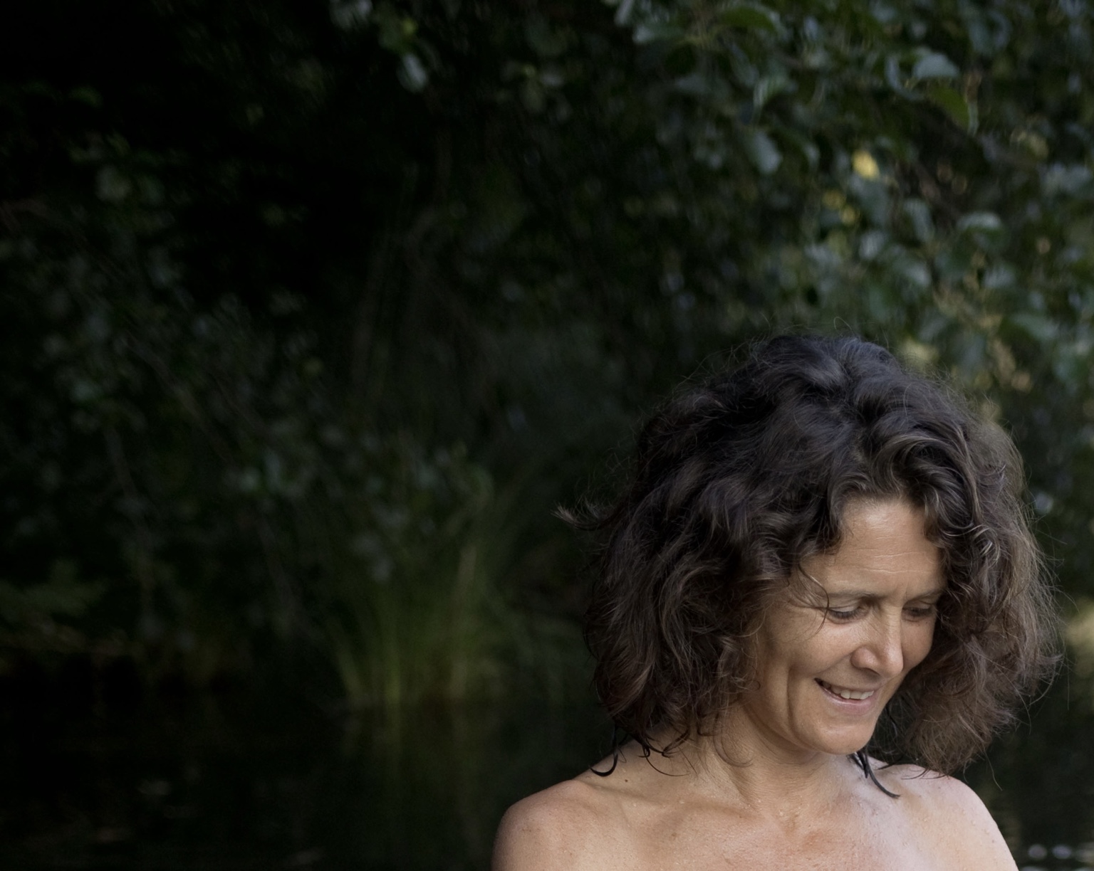 Christina lächelt ruhig am Wasser